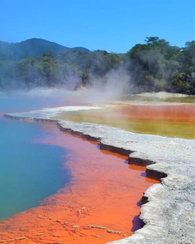 steaming orange and blue geothermal pool in New Zealand