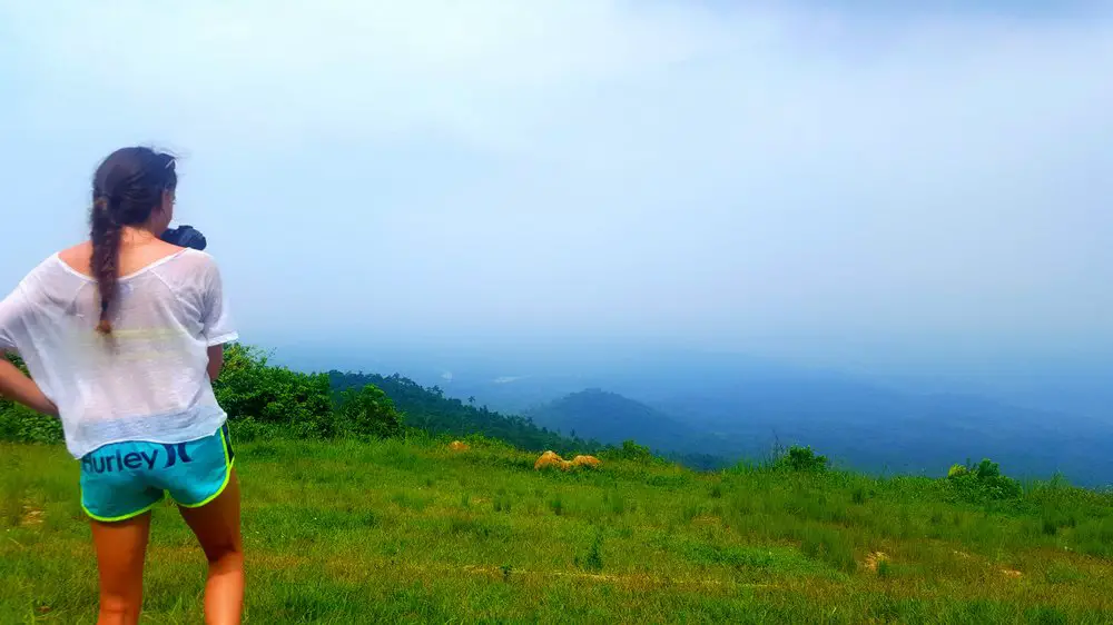 girl standing on hill looking out to thick fog