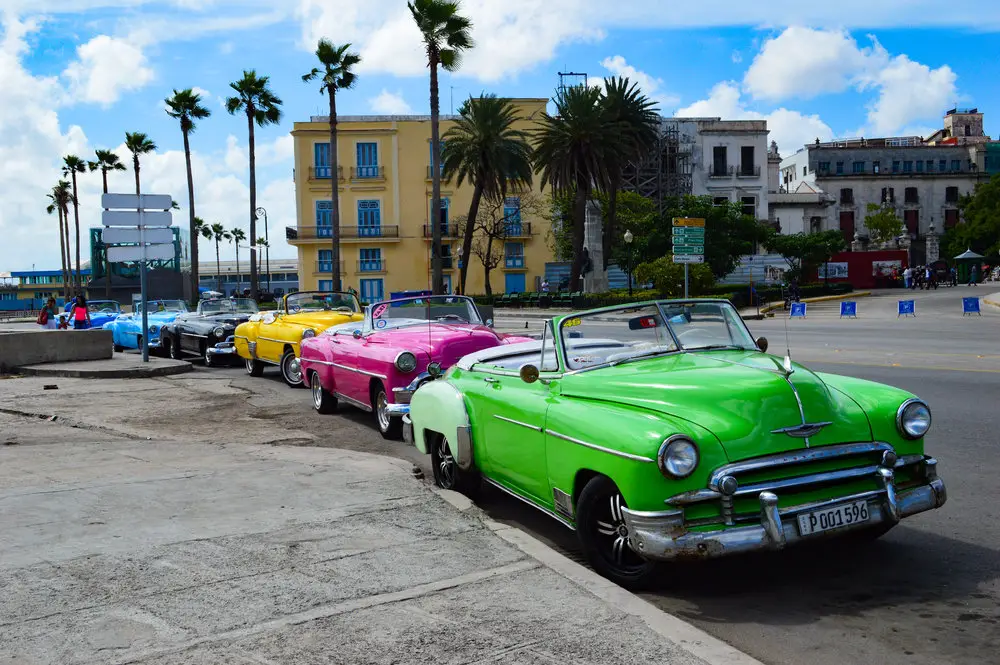 green pink and blur convertible cars lined up in Havana