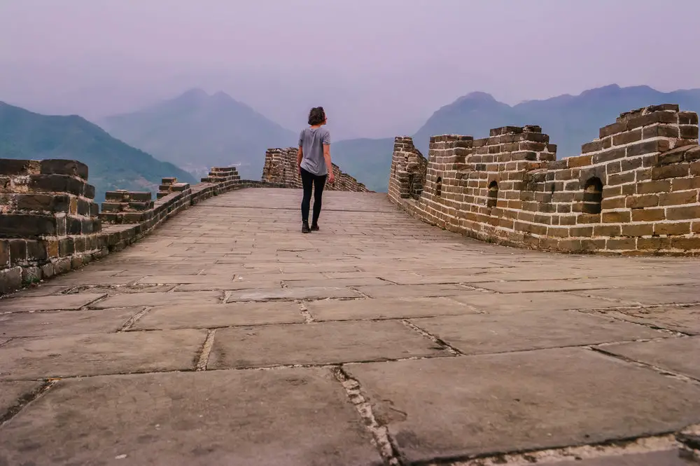 girl walking on great wall of china at sunset