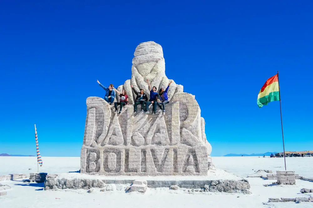 group of tourists sat on dakar bolivia salt monument 