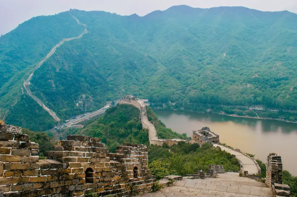 crumbling great wall of chine with a lake reflecting the sunset