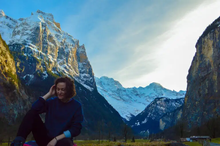 girl sat on a rock with swiss mountains