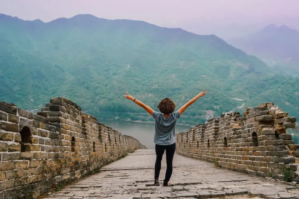 girl raising arms on the great wall of china