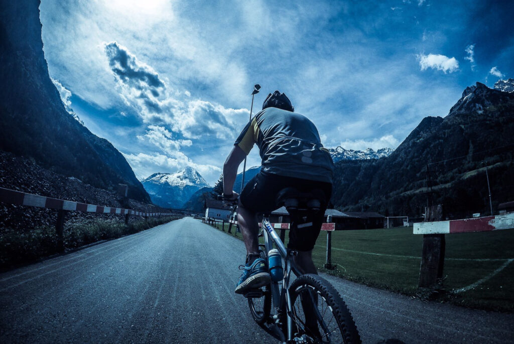 man cycling on bike with moutains as backdrop