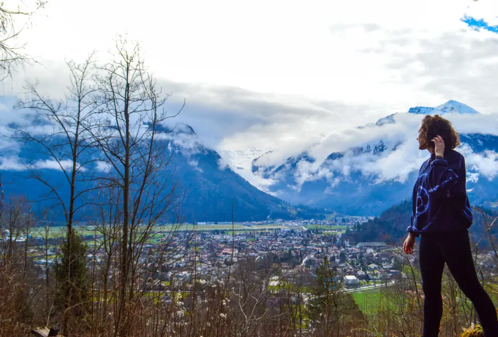 girl standing alone with a backdrop of mountains in Switzerland