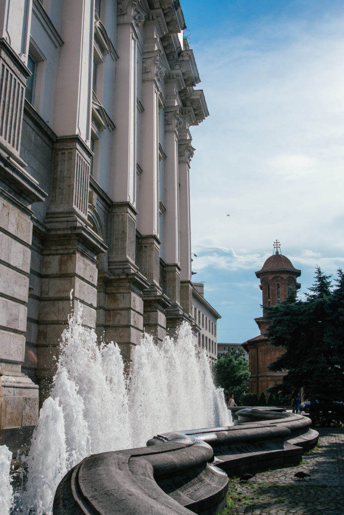 a water fountain in front of a grand building in Bucharest