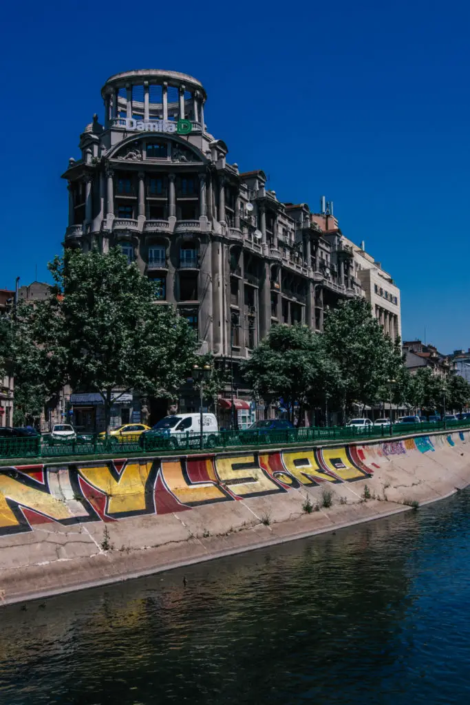 graffiti and grand building in front of Bucharests river