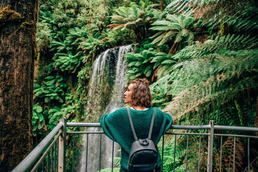 girl standing in front of waterfall in the otways rainforest