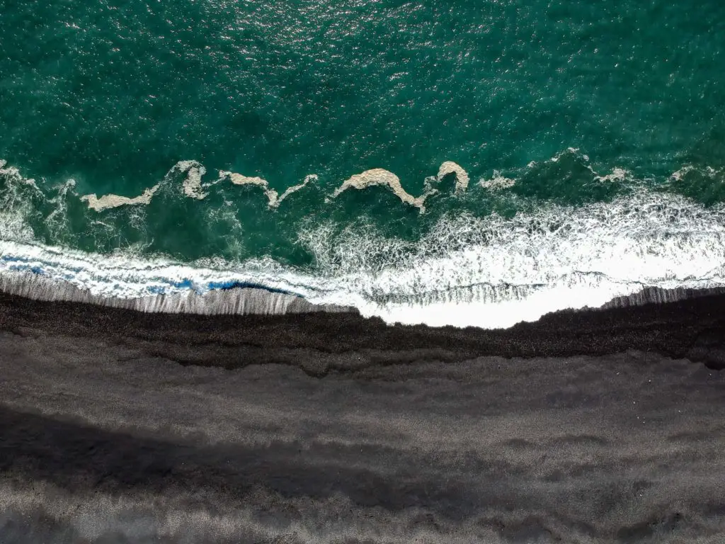 Ariel shot of sea and black sand