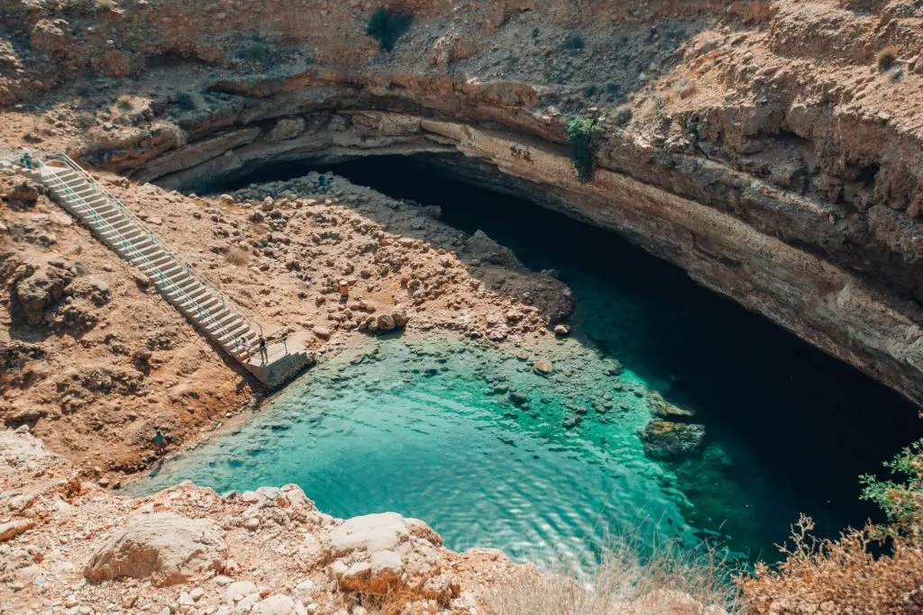 rocky sinkhole with pale blue water