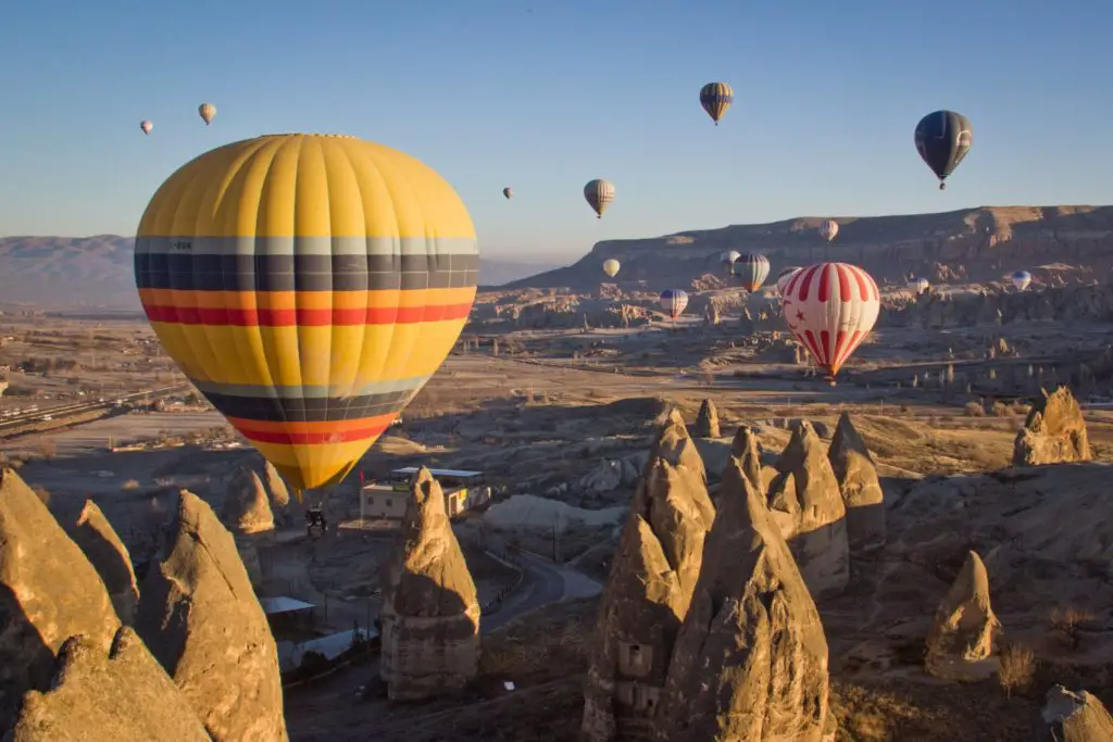 hot air balloons over rocky outcrops