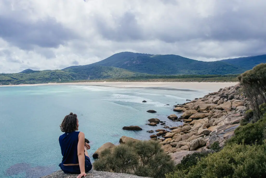 girl sat on rock overlooking sea at Wilsons Prom
