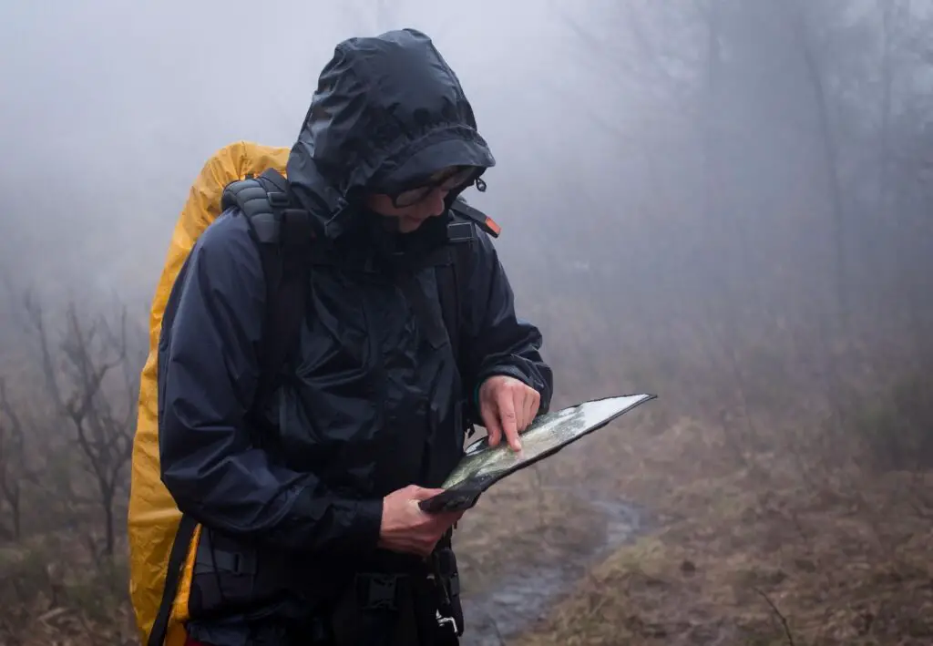 girl in bad weather looking at map in the rain