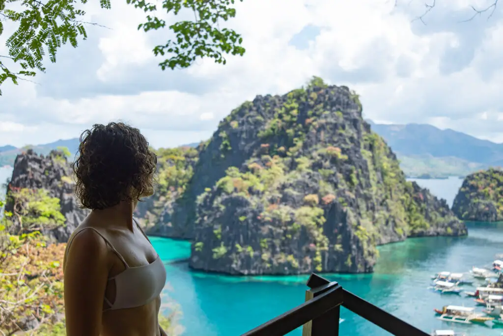 girl in bikini looking out to islands from a view point in Coron