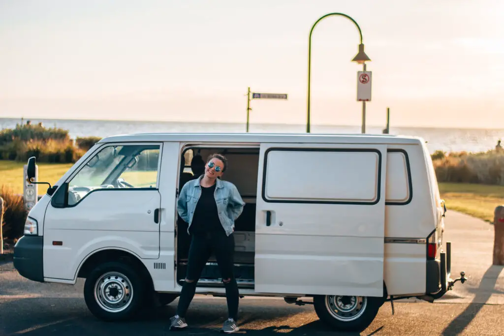 girl standing in front of Ford Econovan camper van