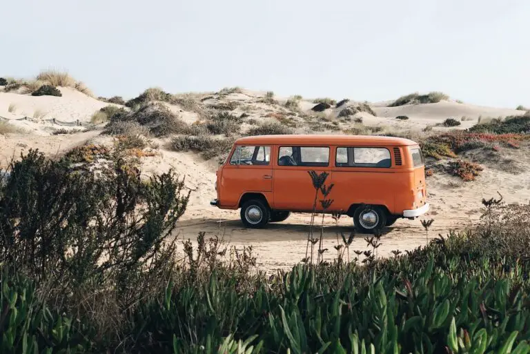 orange campervan within sand dunes