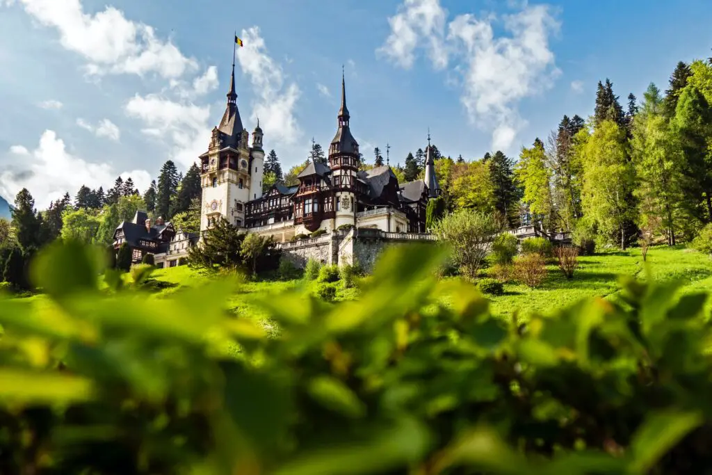 A castle in Romania surrounded by green shubbery