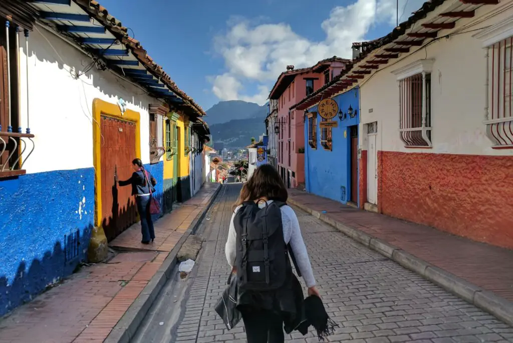 woman walking down colourful street alone