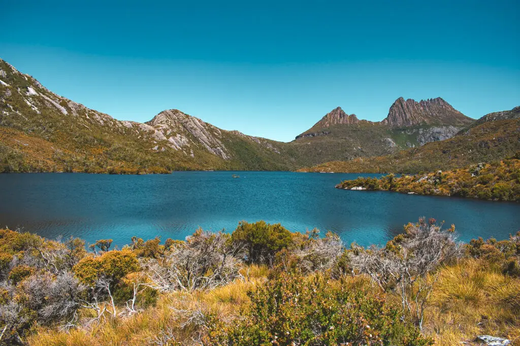 dark blue lake with jagged mountains in background