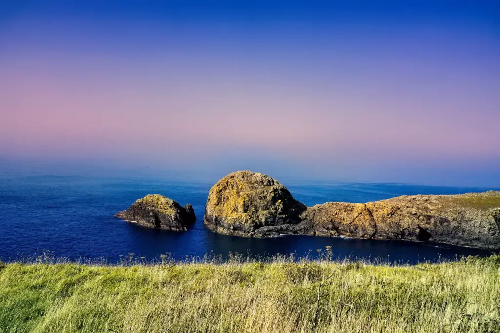 coastal cliffs in wales with a pink sky