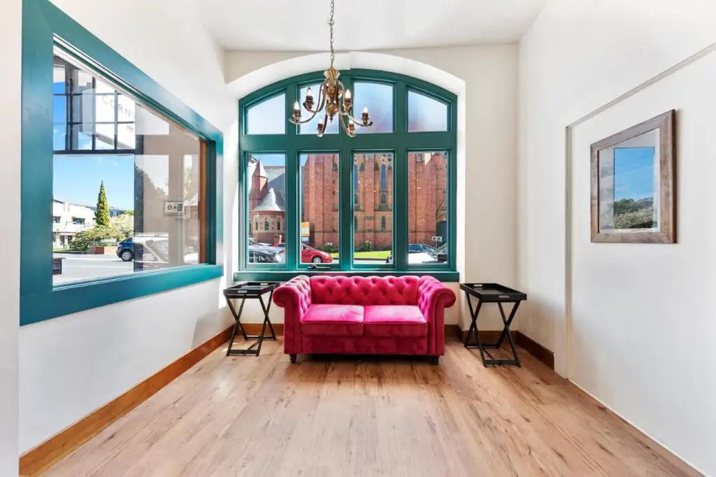 room with large window and red sofa with a chandelier