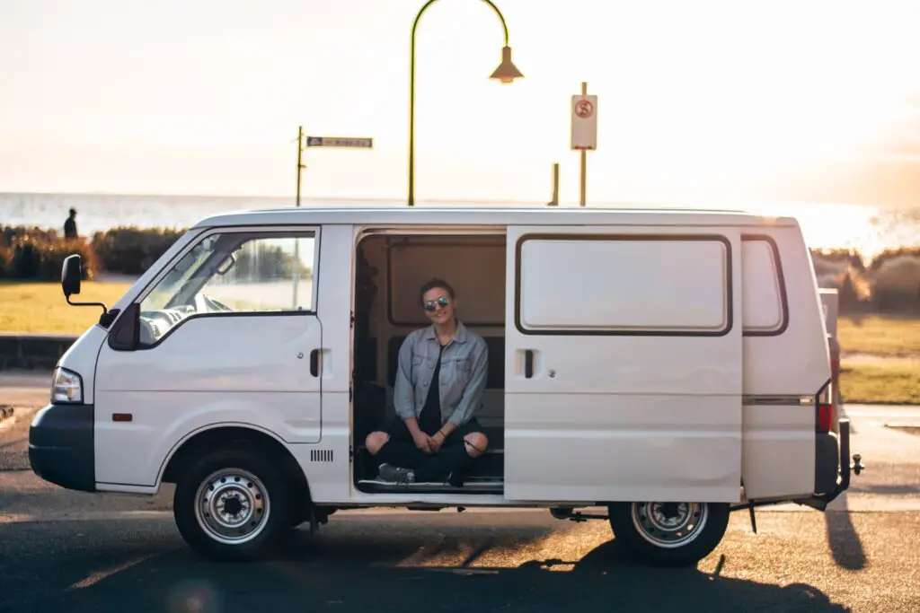 girl sat in doorway of an empty 2004 Ford Econovan