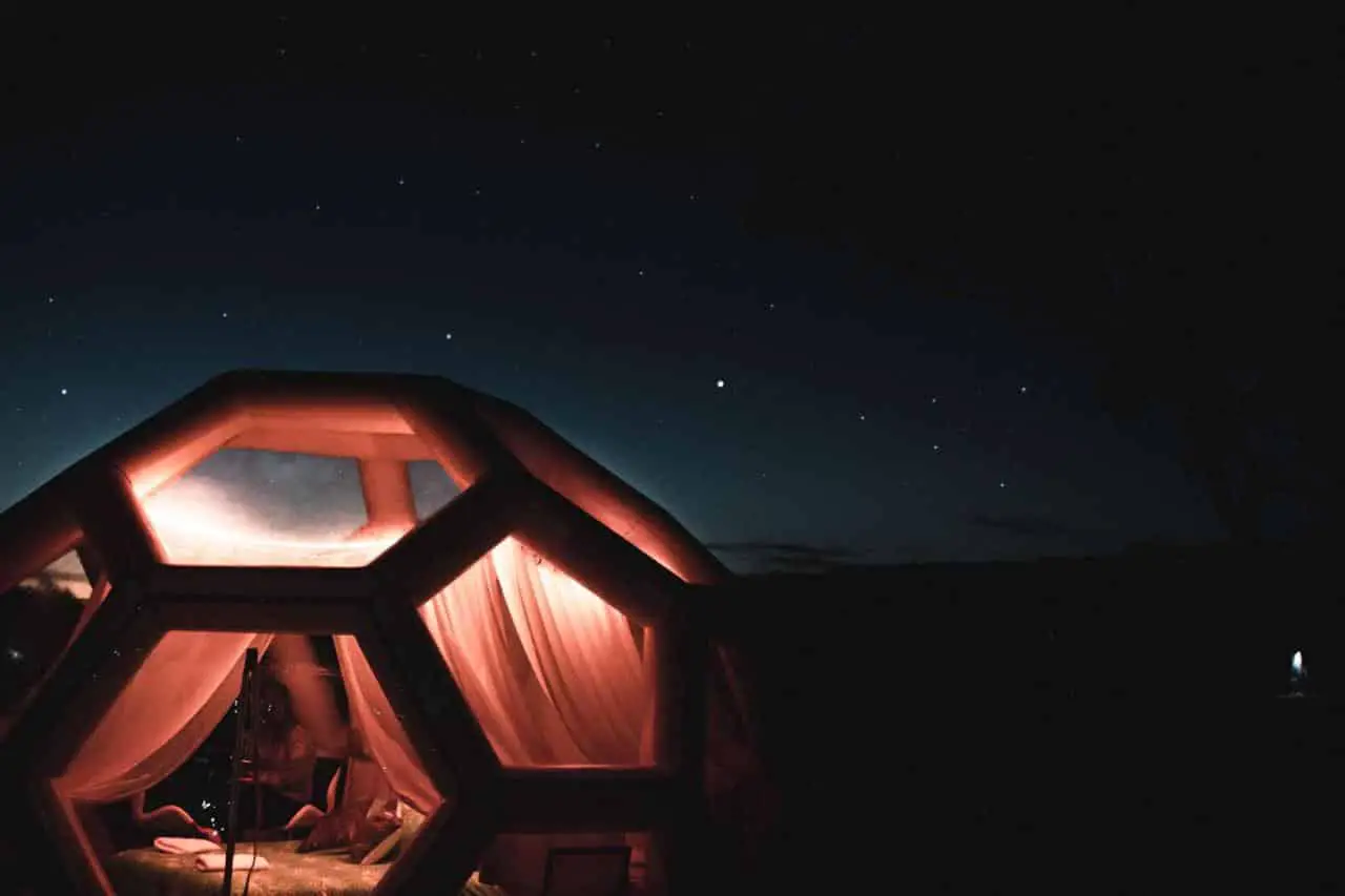 hexagonal tent bubble lit up at night