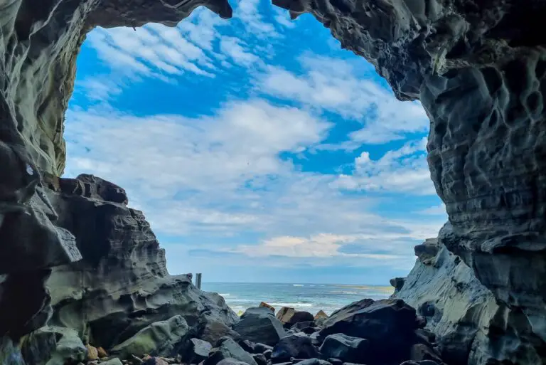 Entrance of a cave with the sea and sky in the background