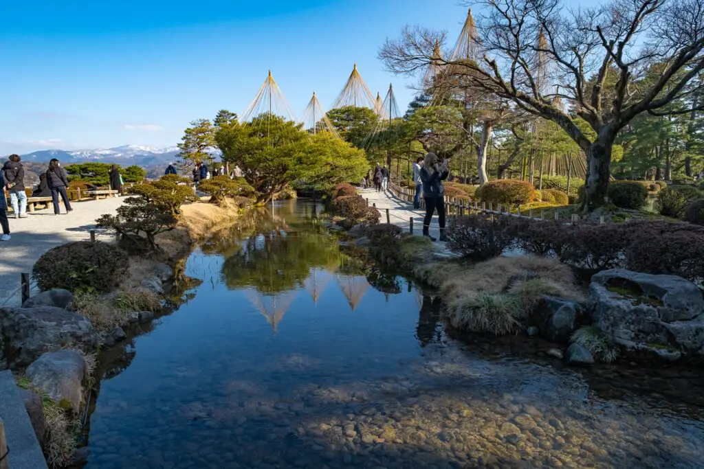 the river in Kenrouken garden with a backdrop of snow capped mountains