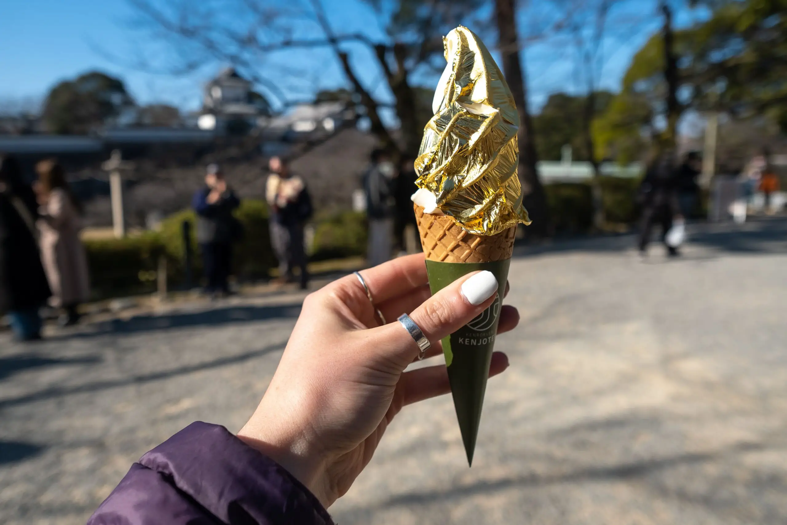 hand holding an icecream draped in gold leaf